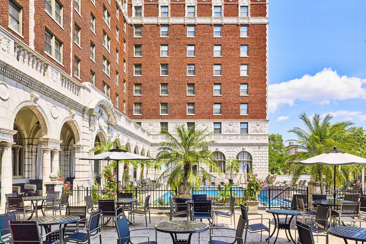 a patio with chairs and tables in front of a building