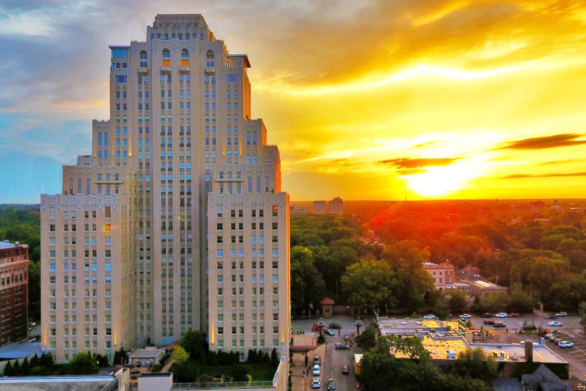 a tall building with many windows and a city in the background