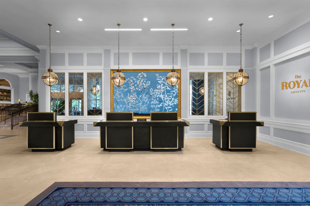 a room with a blue rug and black desks
