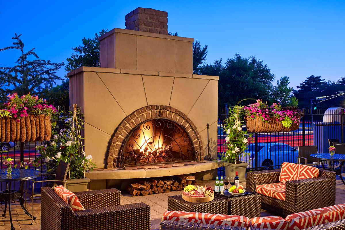 a outdoor fireplace with chairs and a table
