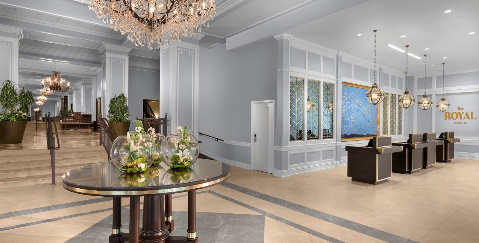 a room with a chandelier and a table with flowers