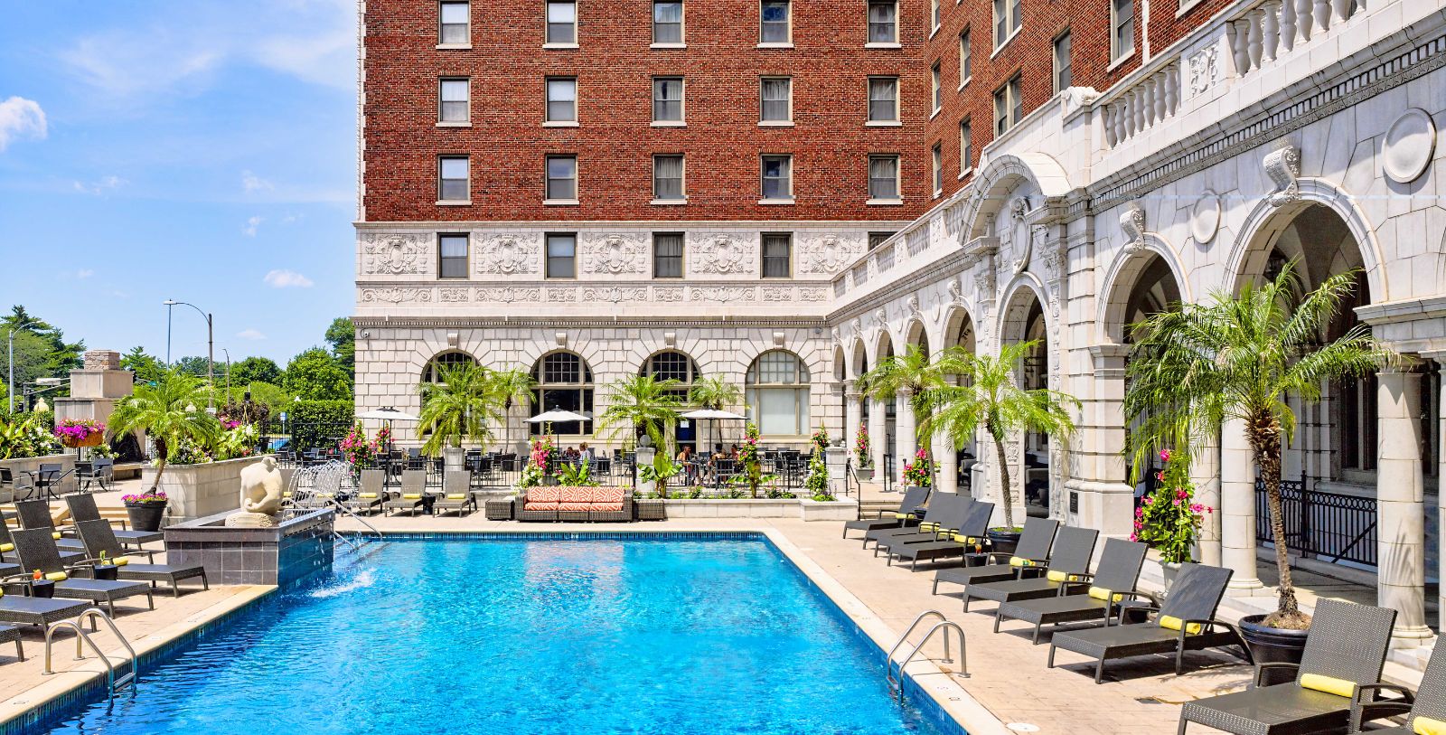 a pool with chairs and a building in the background