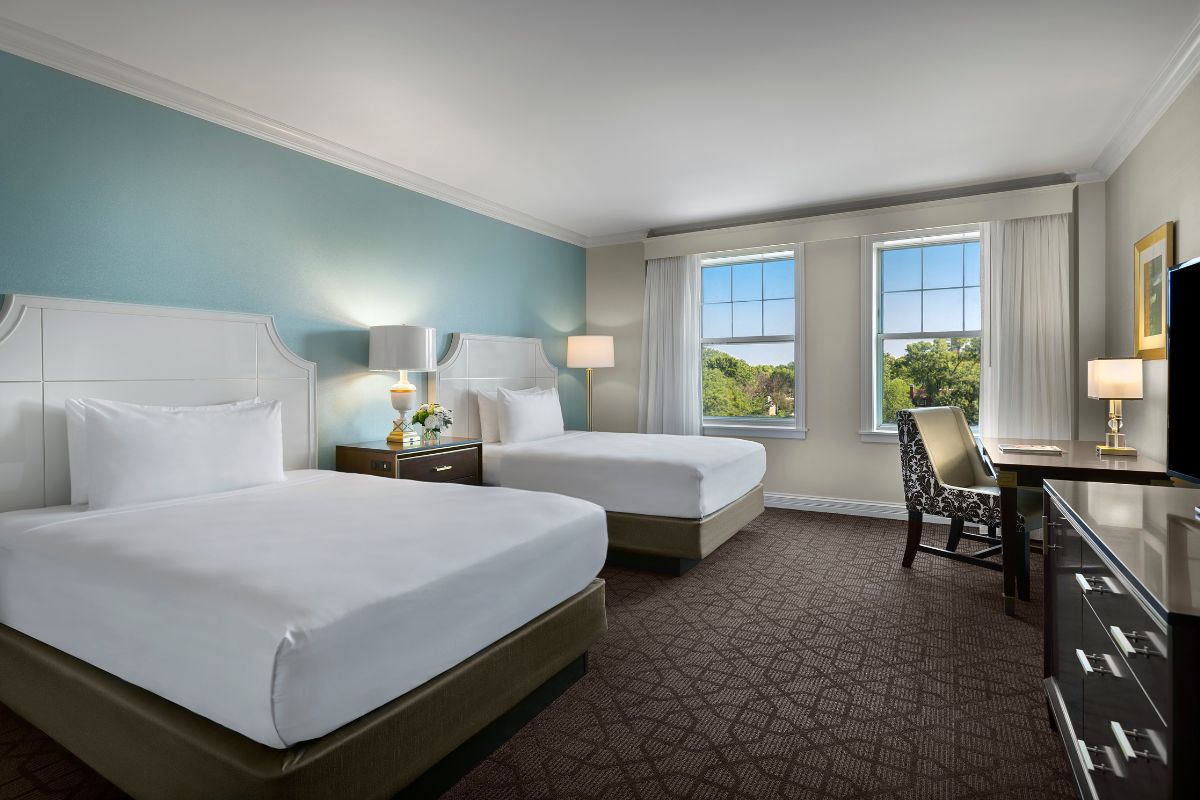a room with two beds and a chair