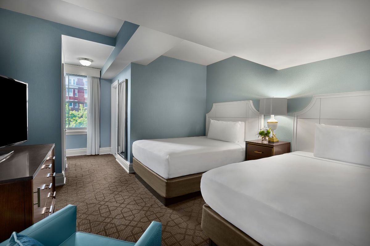 a room with two beds and a lamp