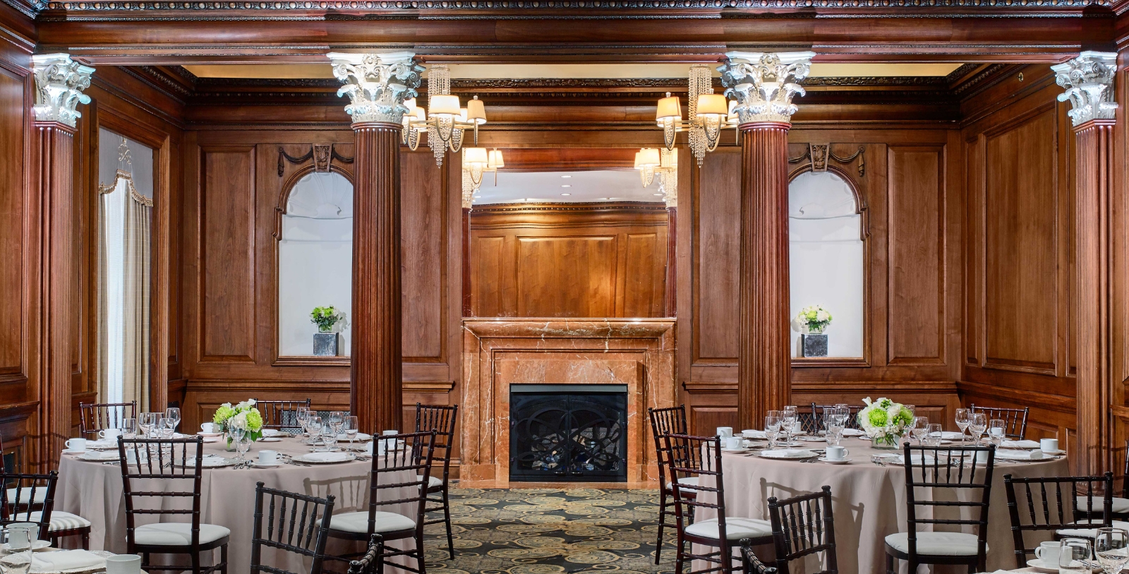 a room with a fireplace and tables