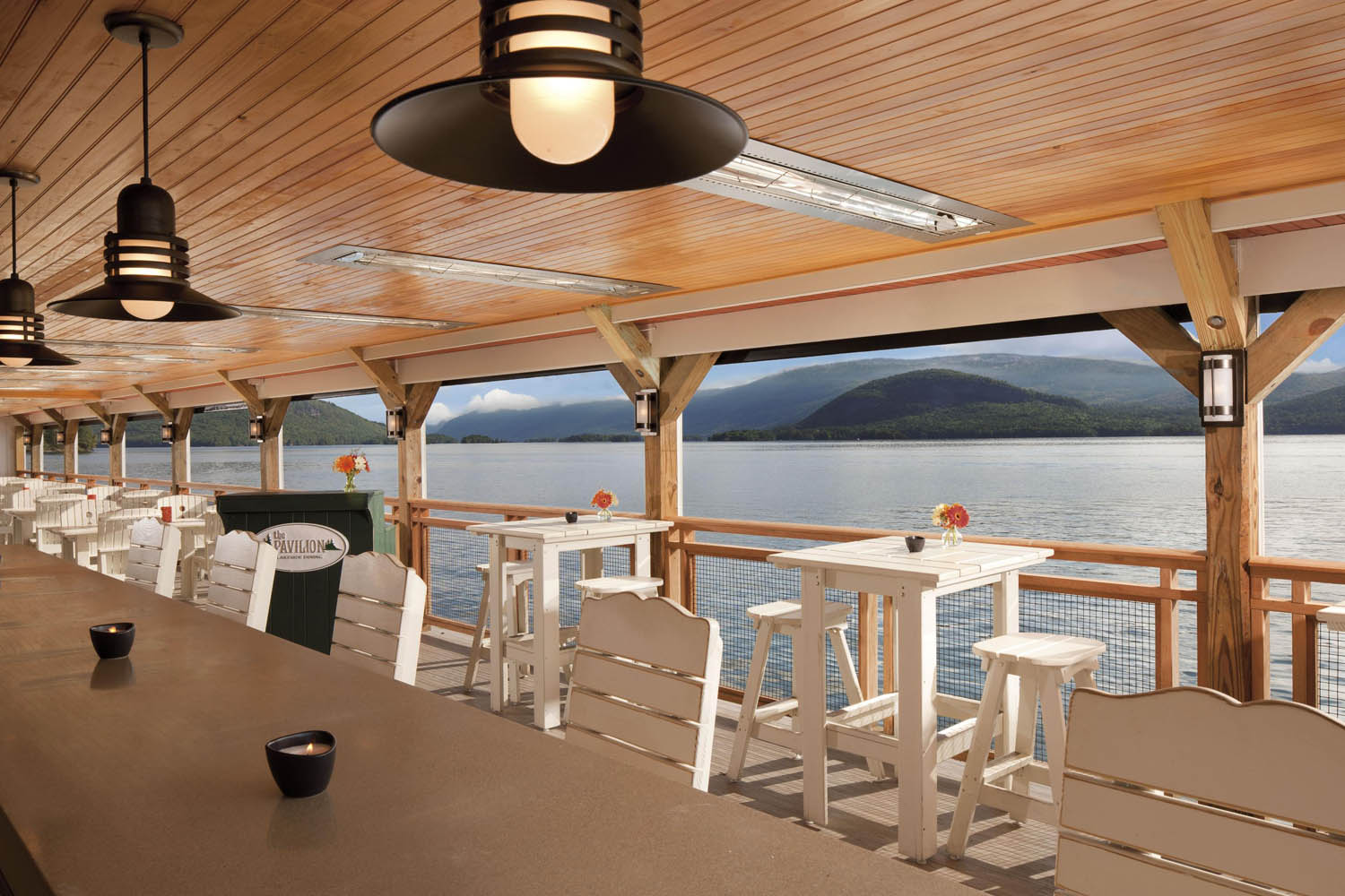 a table and chairs on a deck overlooking a body of water