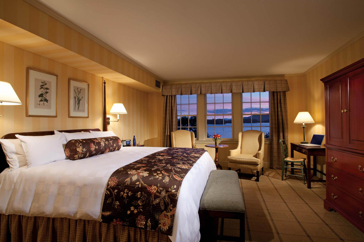 a room with a bed and chairs