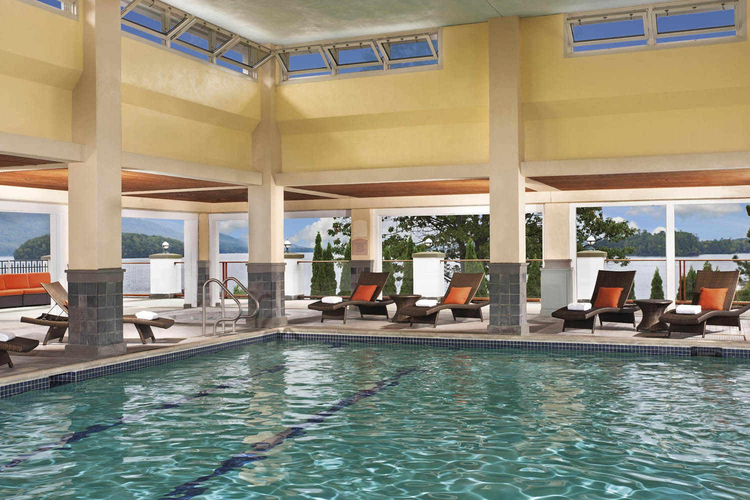 a swimming pool with chairs and a large roof
