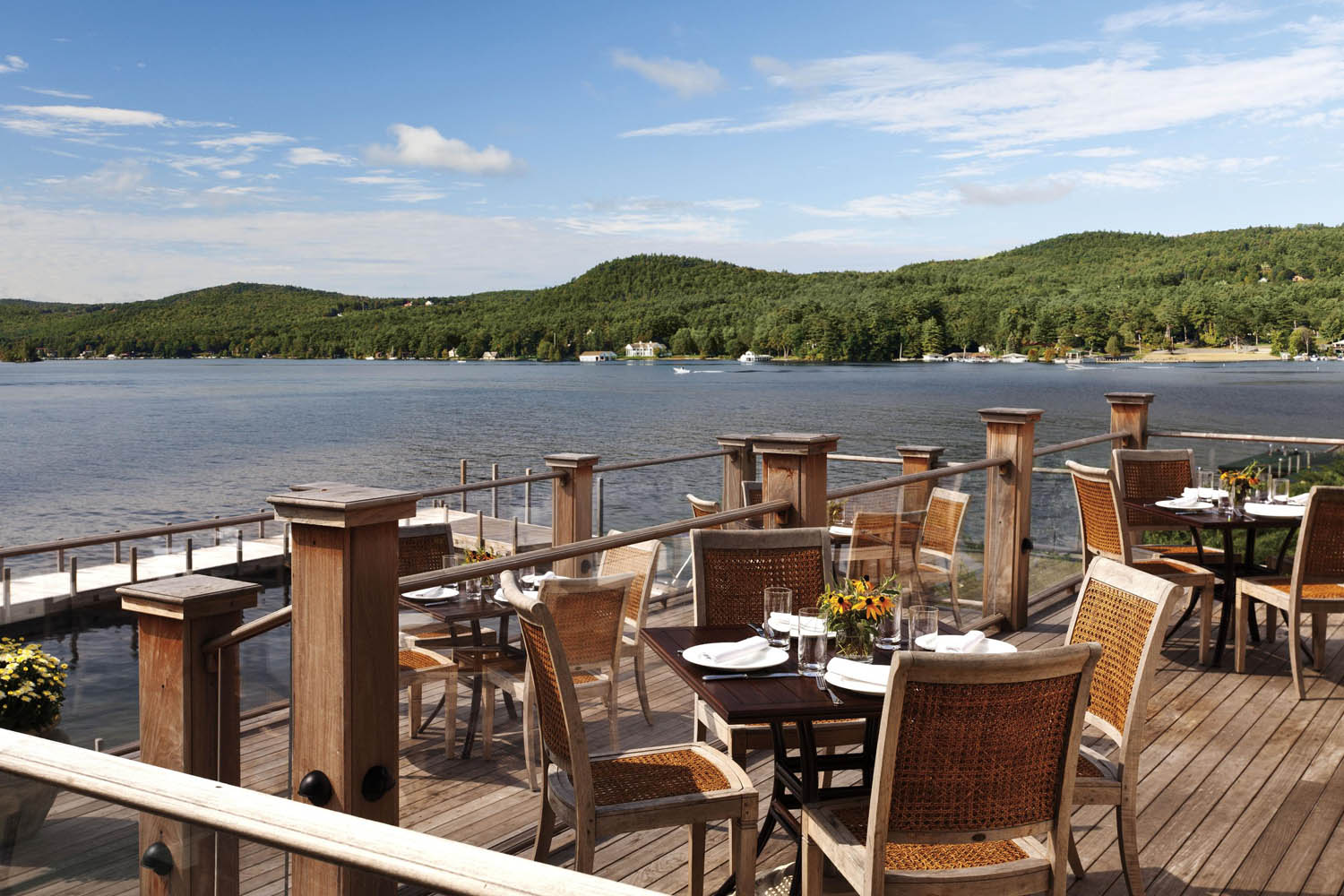 a table and chairs on a deck overlooking a lake