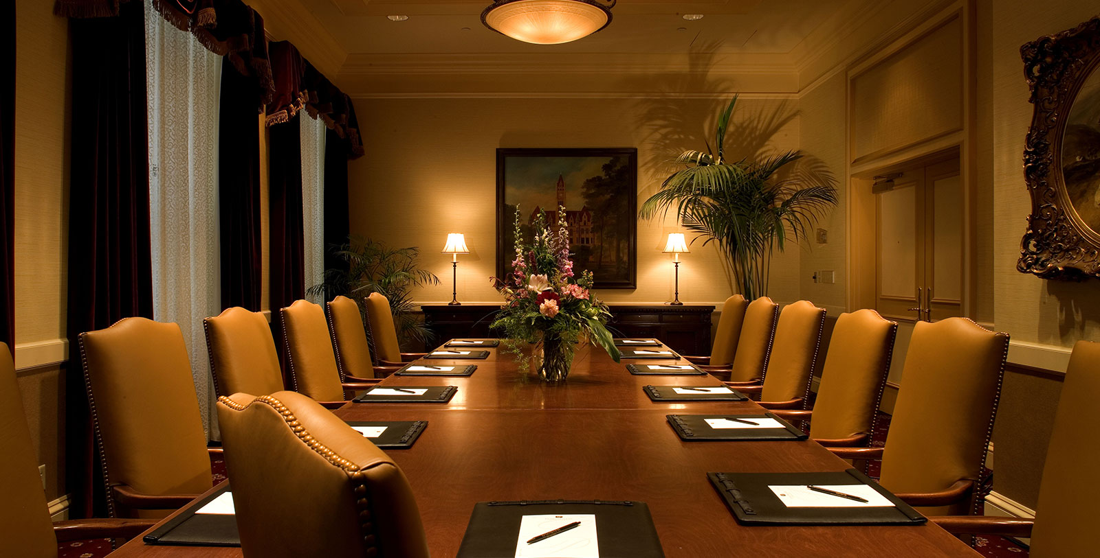 a table with chairs and a vase of flowers