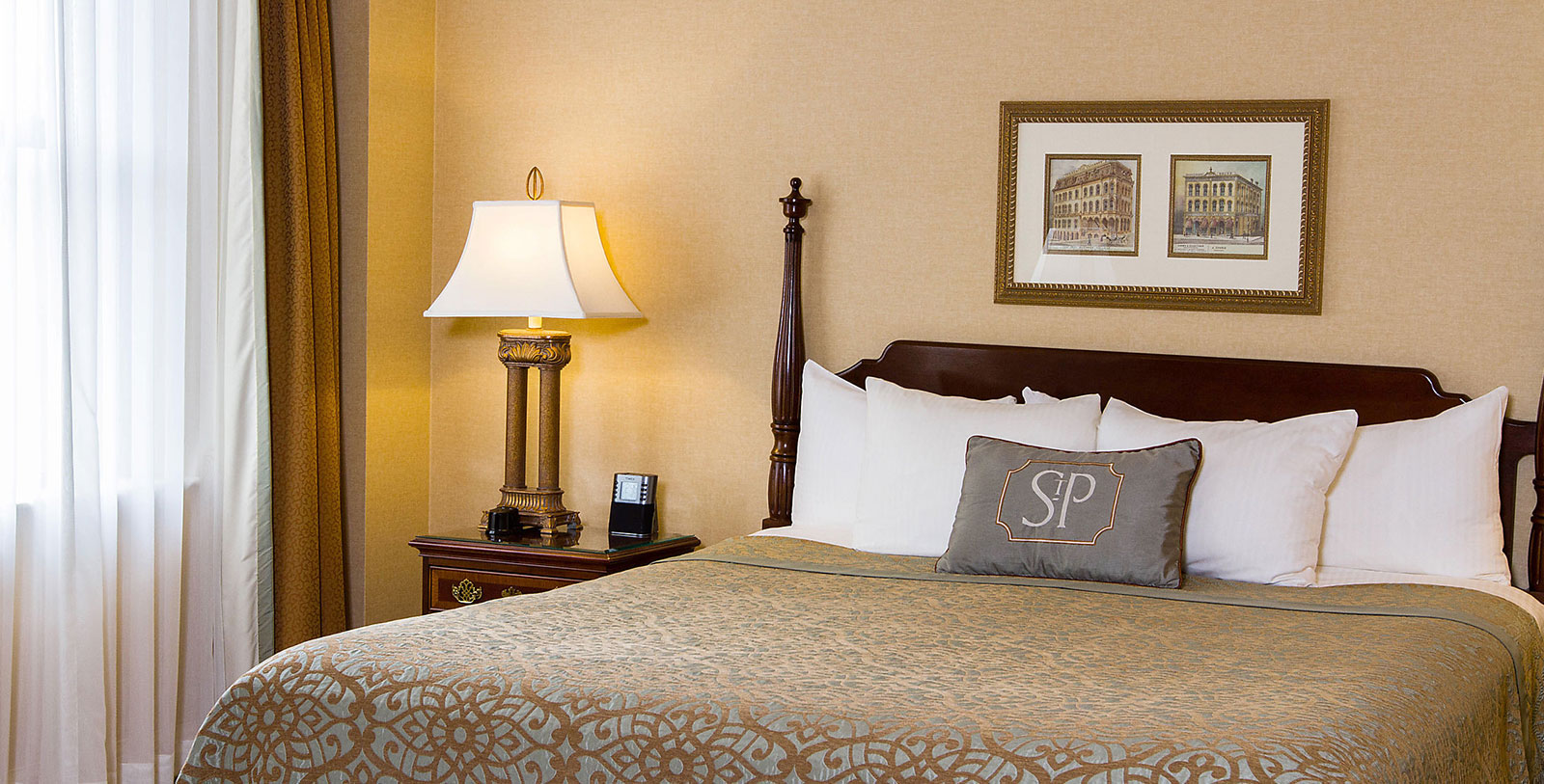 a bed with a lamp and picture on the wall