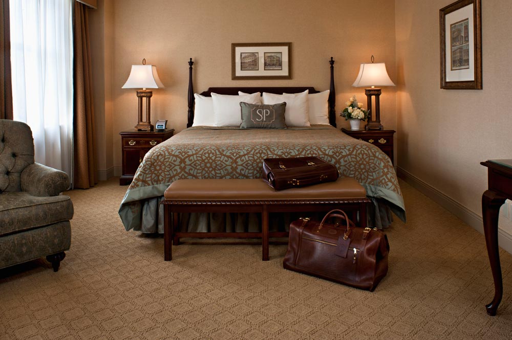 a hotel room with a bed and a bench