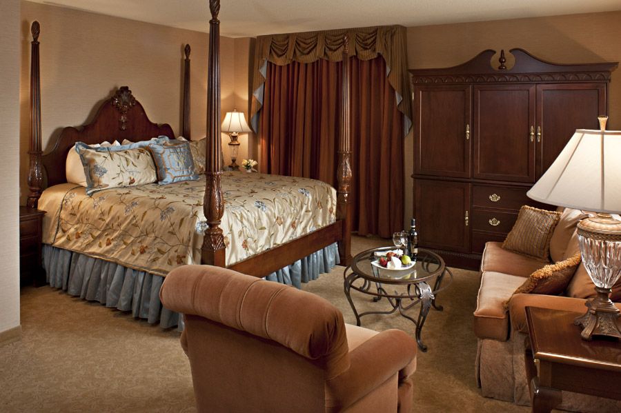a bedroom with a four poster bed and a couch
