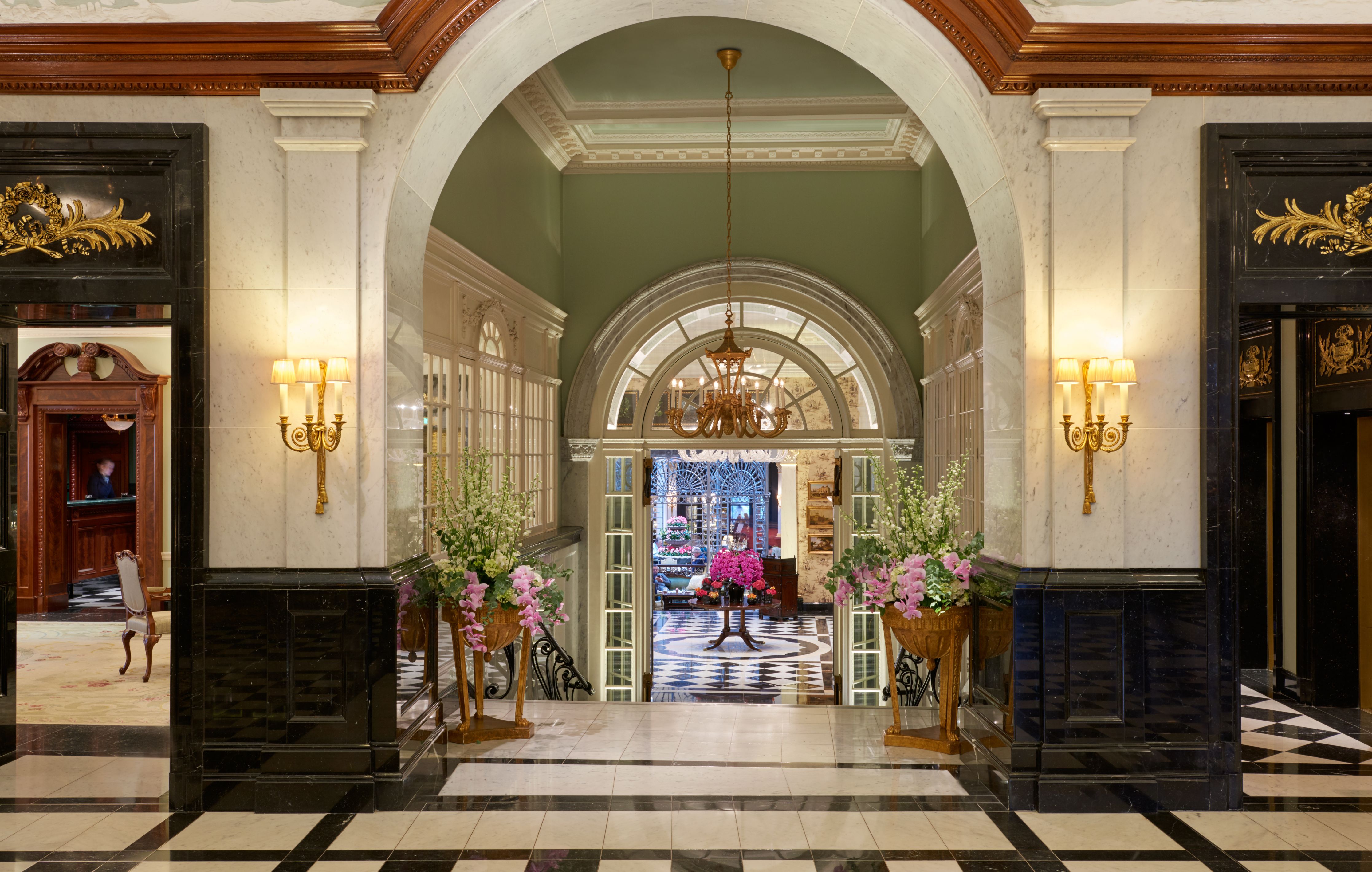 a hallway with flowers and a chandelier
