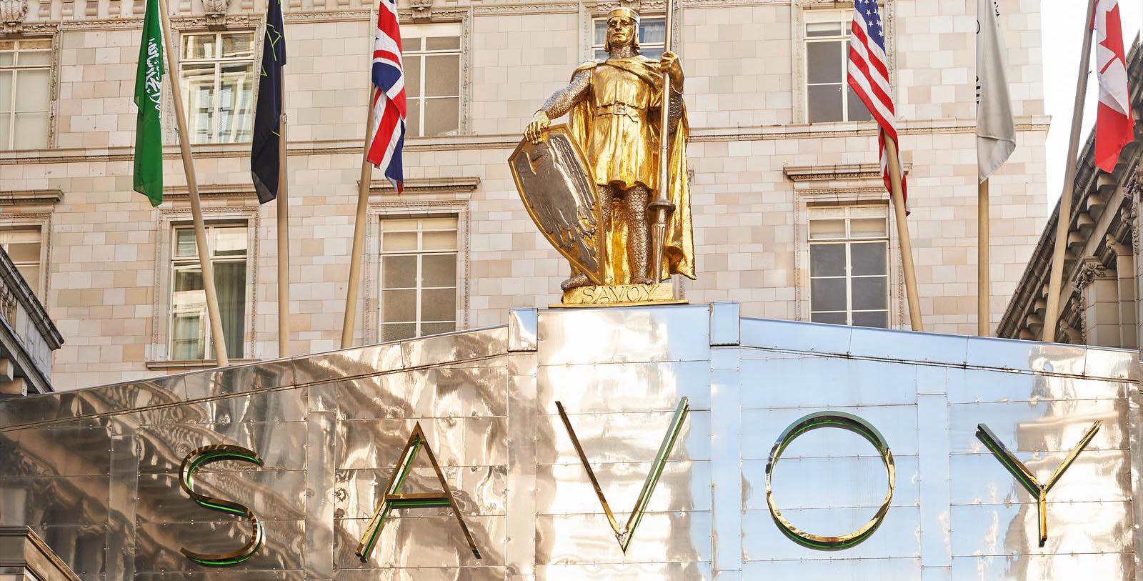 a statue of a man holding a shield and a sword on top of a building