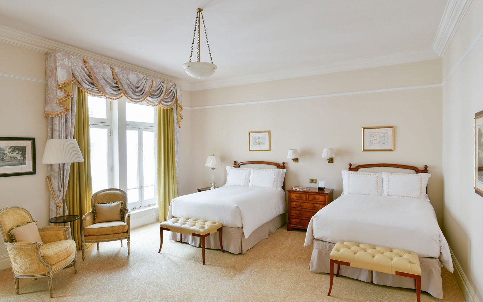 a room with two beds and a chair