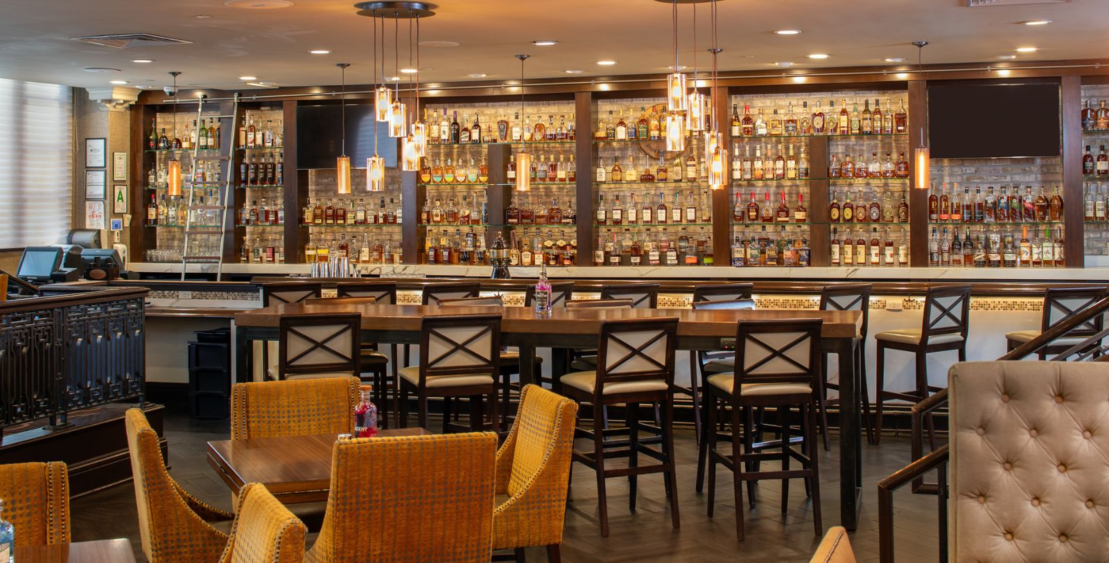 a bar with a long table and chairs