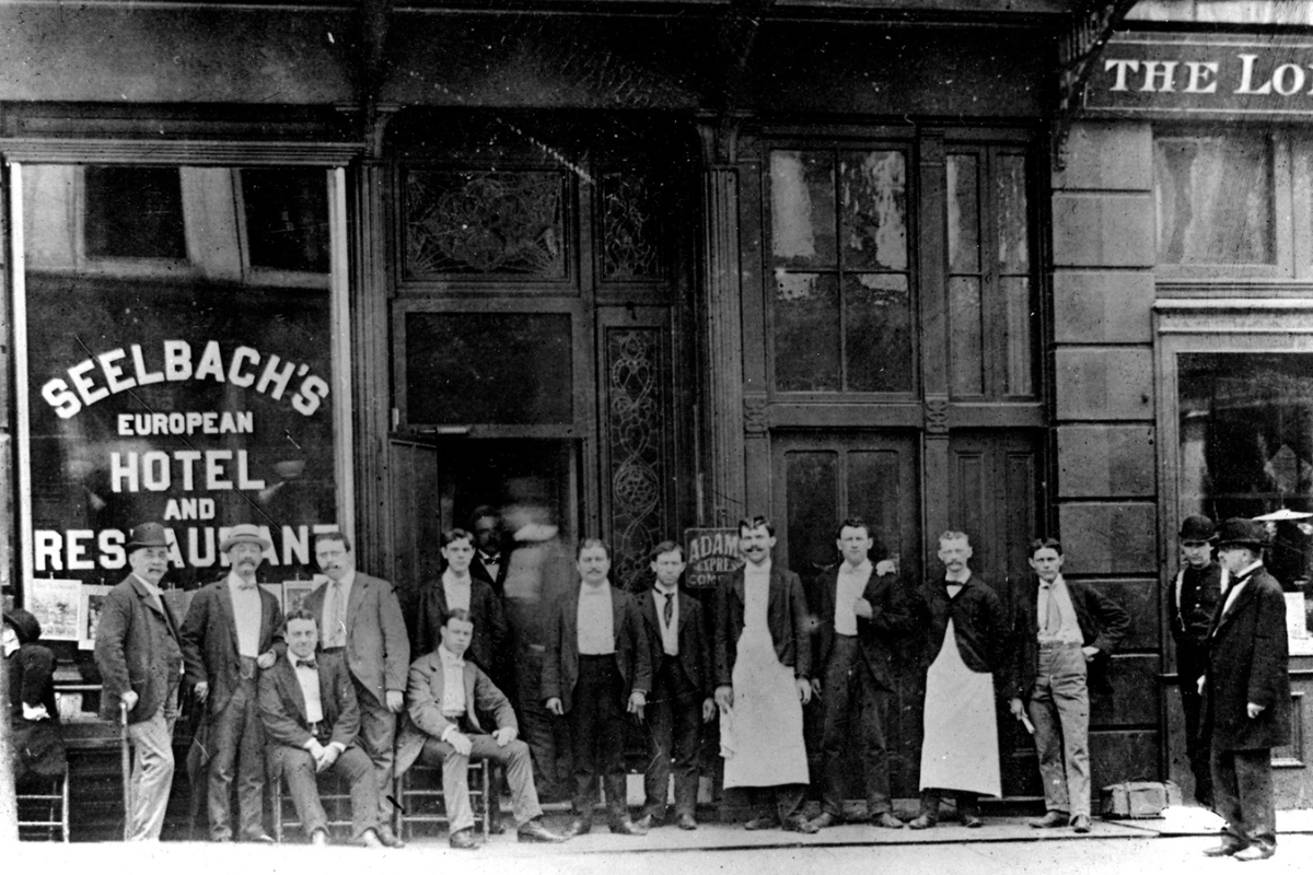 a group of men standing outside a restaurant