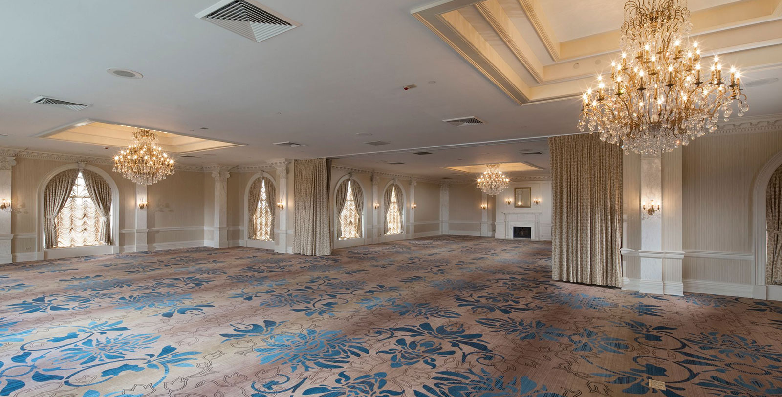 a large room with a fireplace and chandeliers