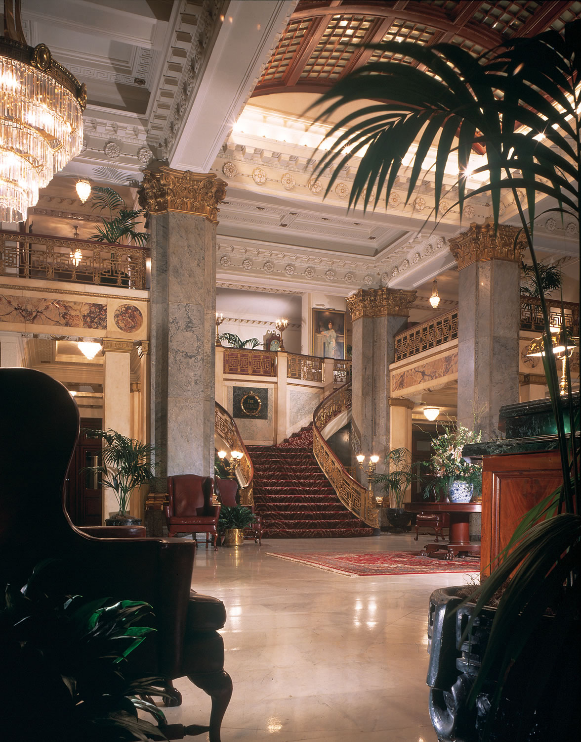 a large lobby with a staircase and chandeliers