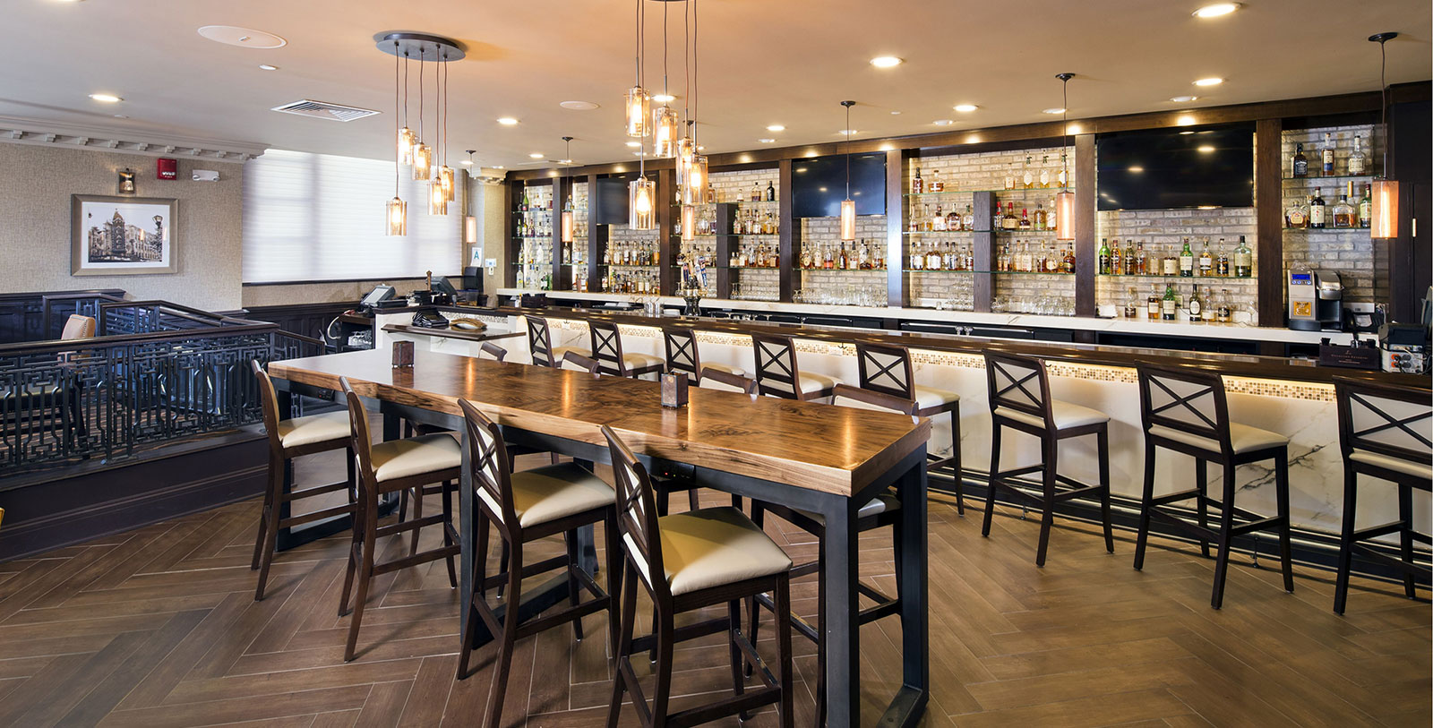a long table with chairs in a room with a bar