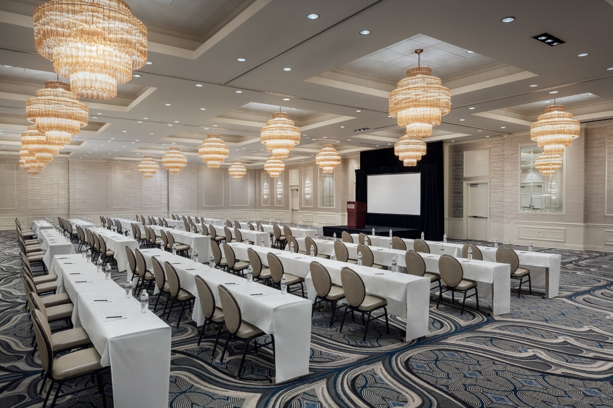 a room with tables and chairs and chandeliers