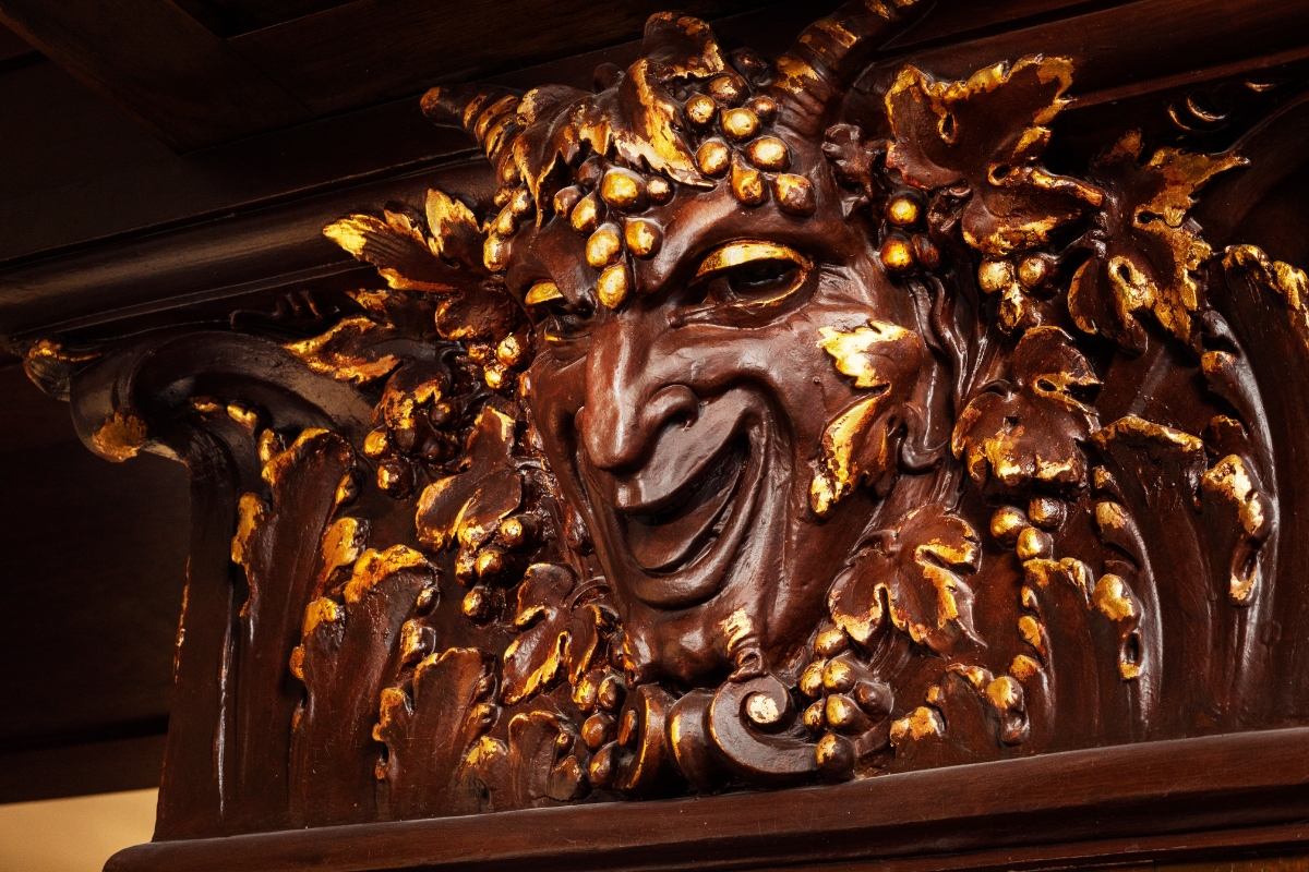 a sculpture of a face with gold leaves