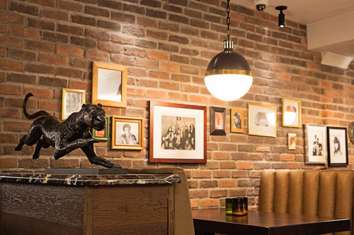 a statue of a panther on a table in a room with a brick wall