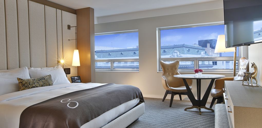 a room with a bed and a table and chairs
