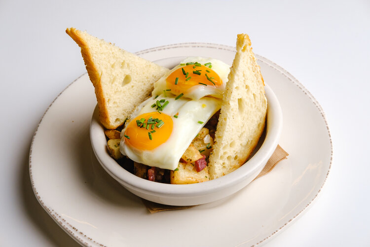 a bowl of food with eggs and bread