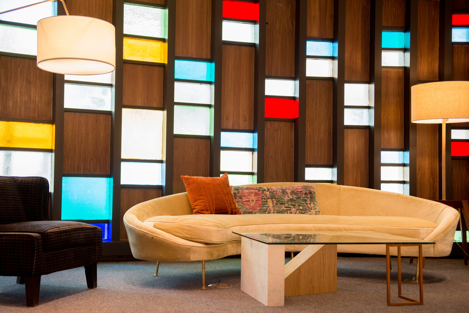 a couch and coffee table in a room with colorful glass panels