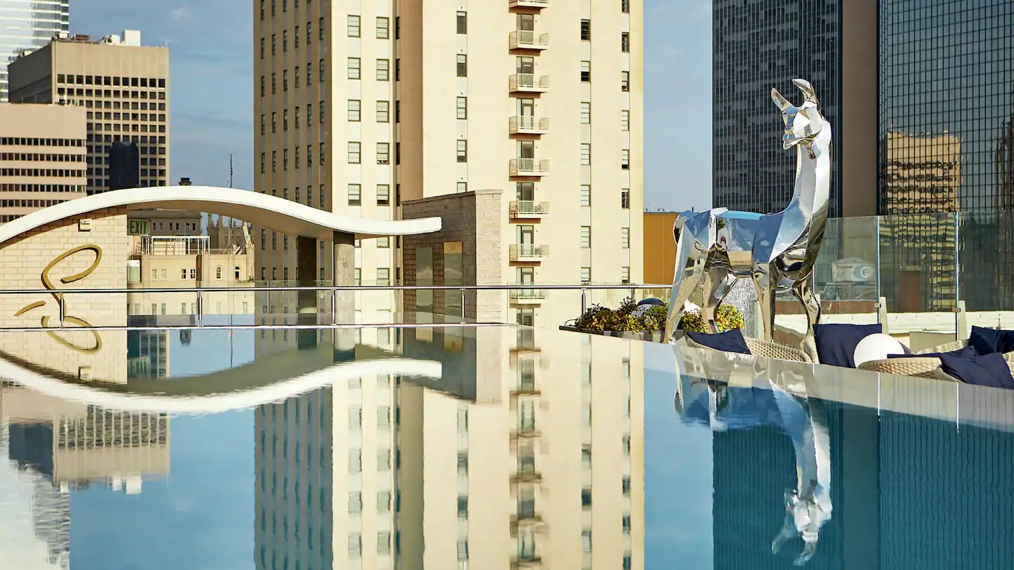 a building with a pool and a statue of a deer