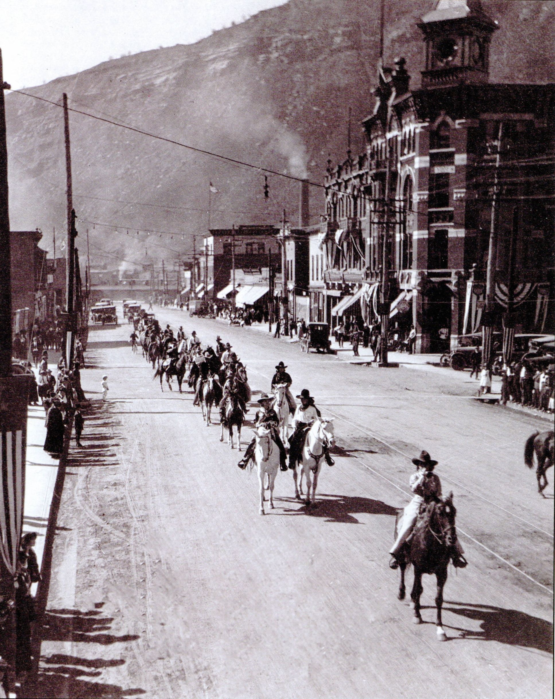 a group of people riding horses in a street