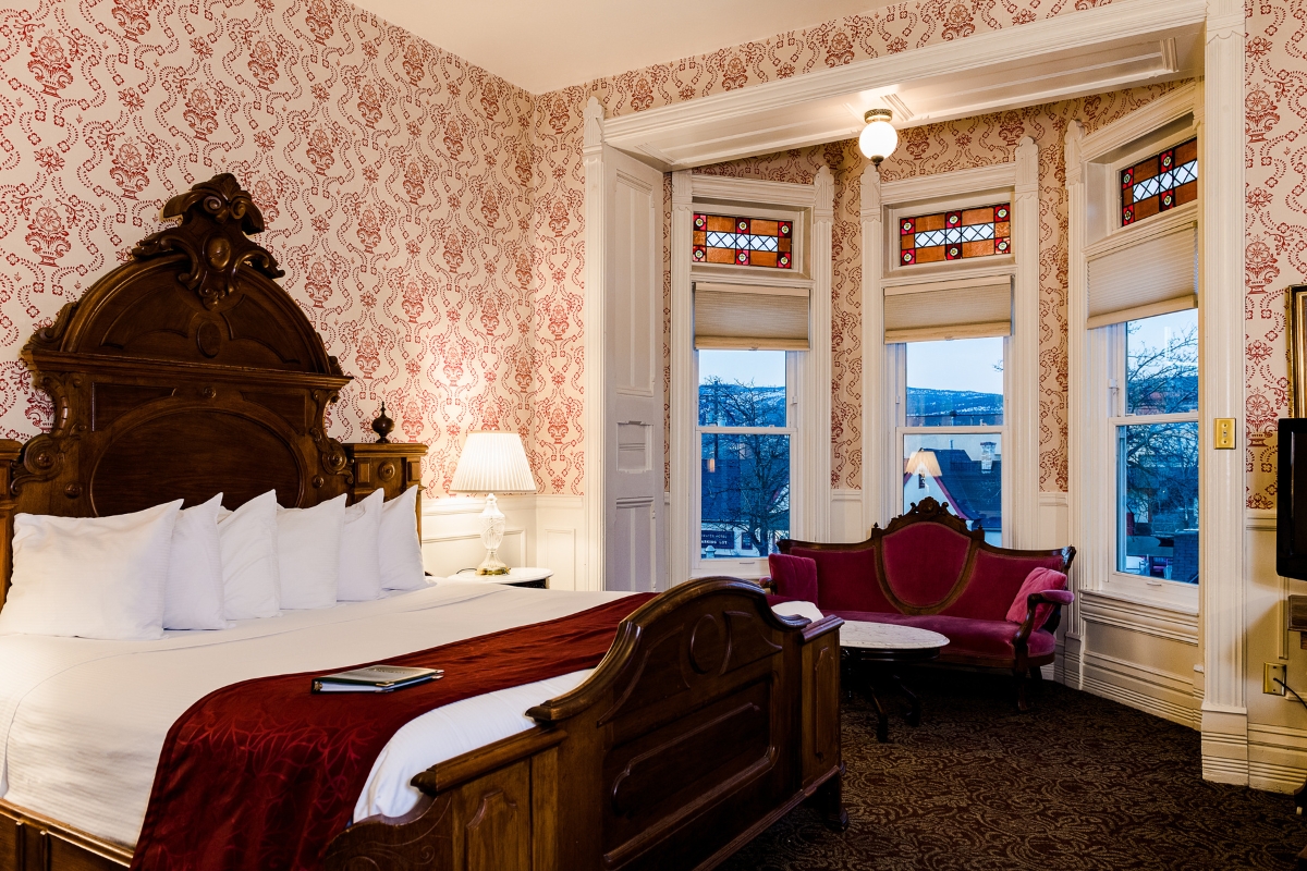 a room with a bed and chairs