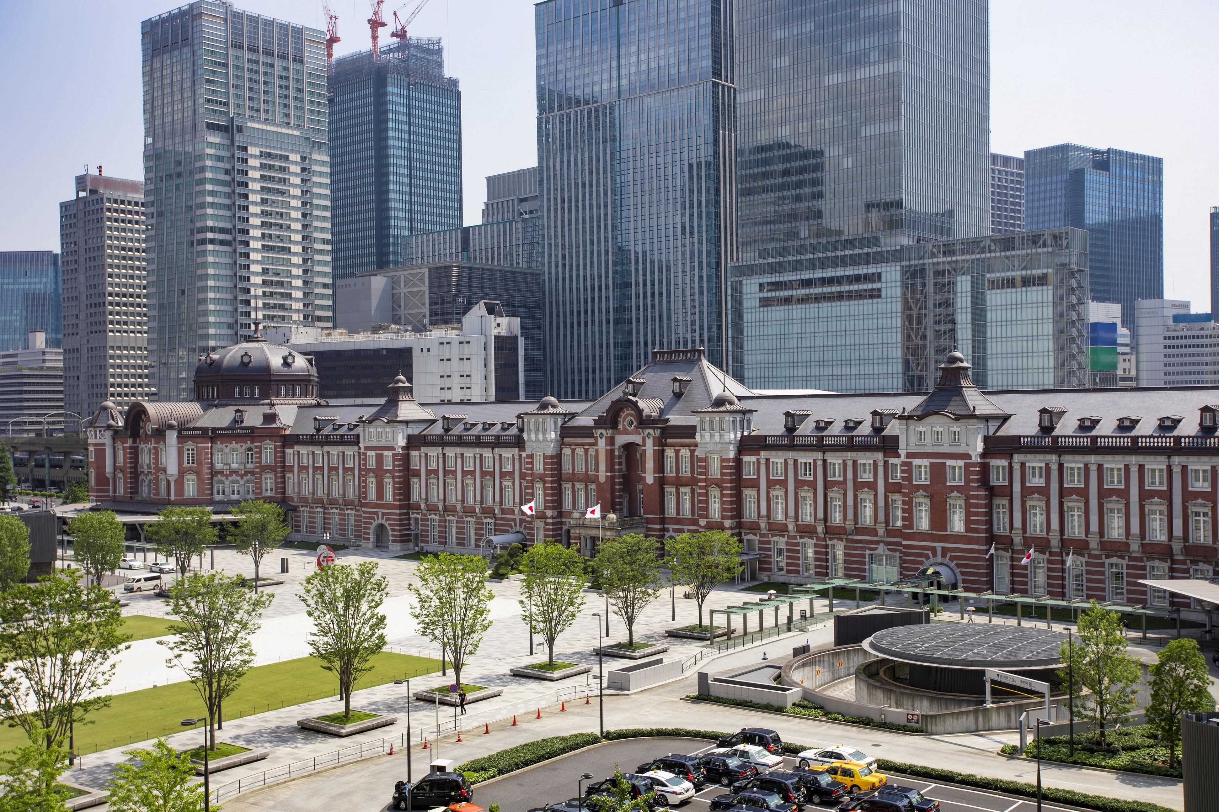 a large building with many cars and trees in front of it