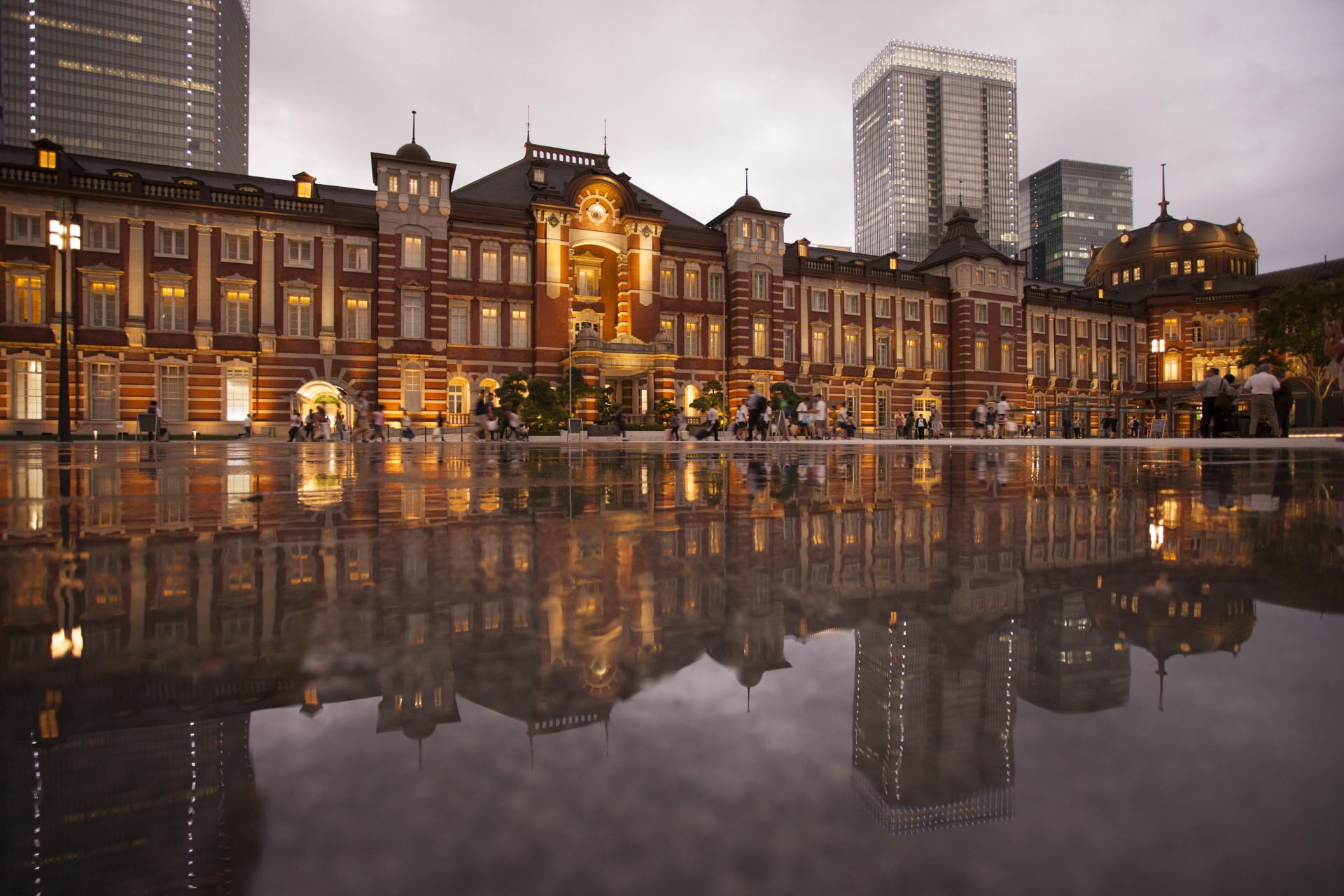 a building with lights and a reflection of a city