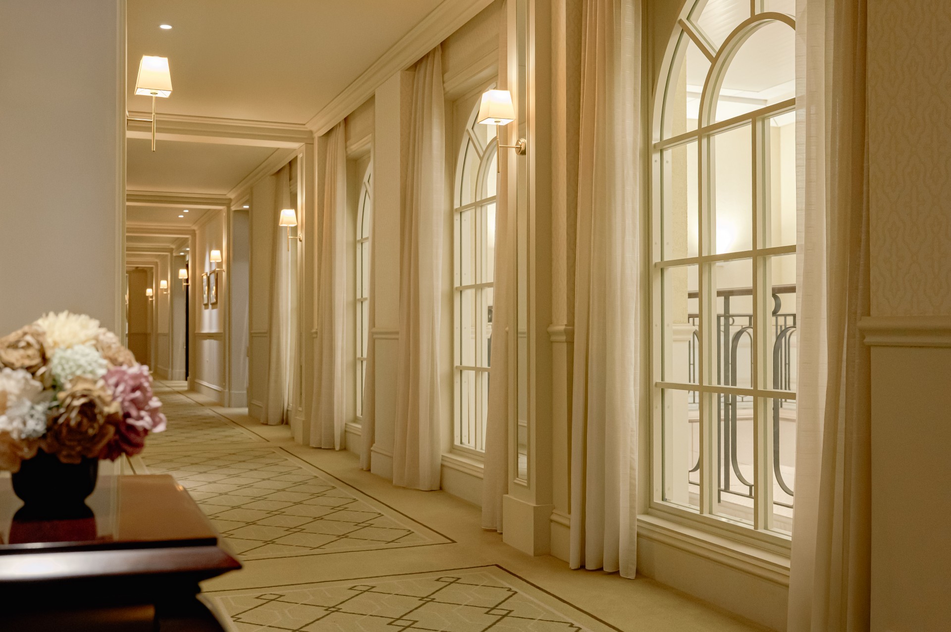 a long hallway with white walls and a bench