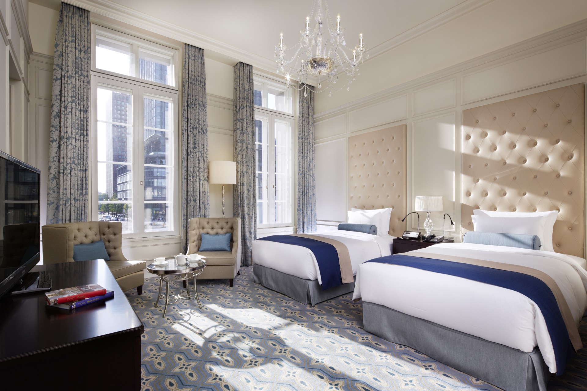 a room with two beds and a chandelier