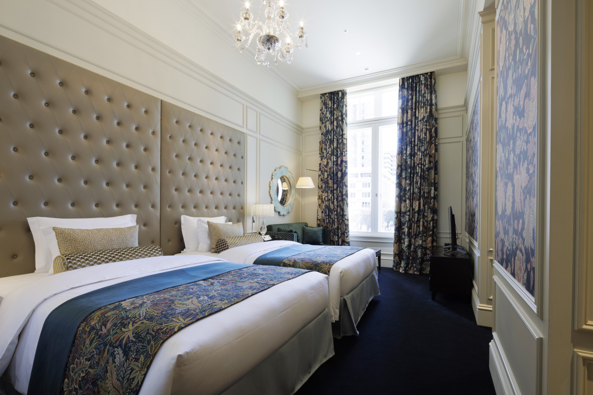 a room with two beds and a chandelier