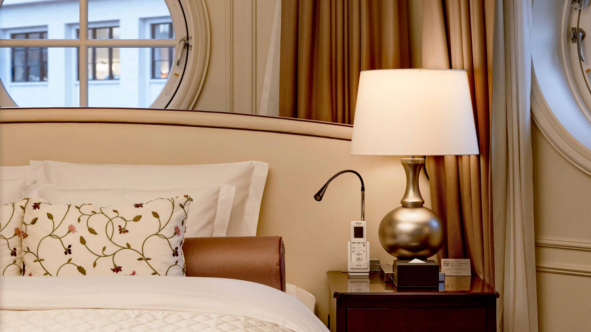 a lamp on a nightstand next to a bed