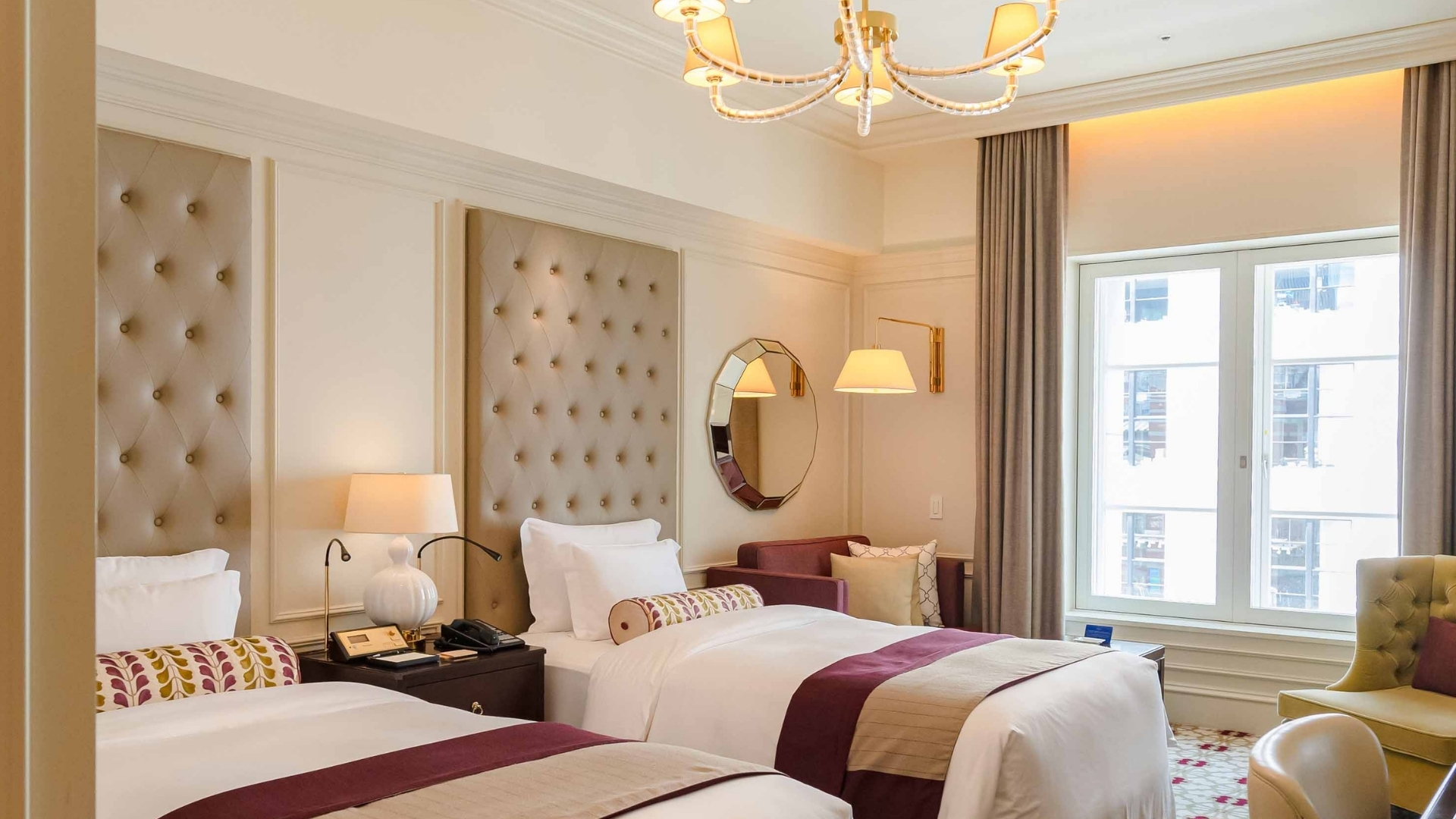 a room with two beds and a chandelier