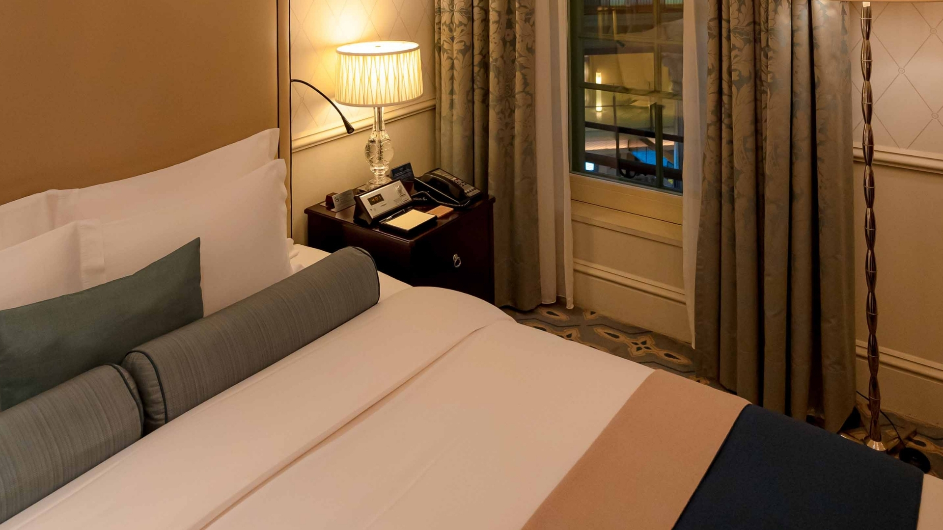 a bed with a lamp next to a window