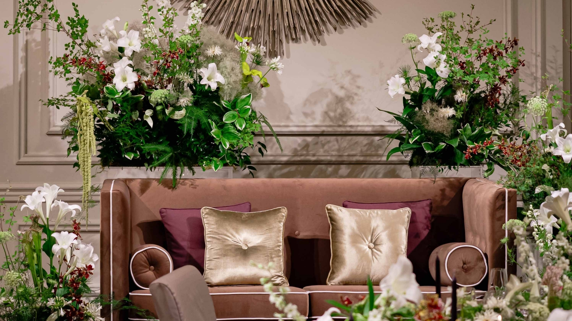 a couch with pillows and flowers on the wall
