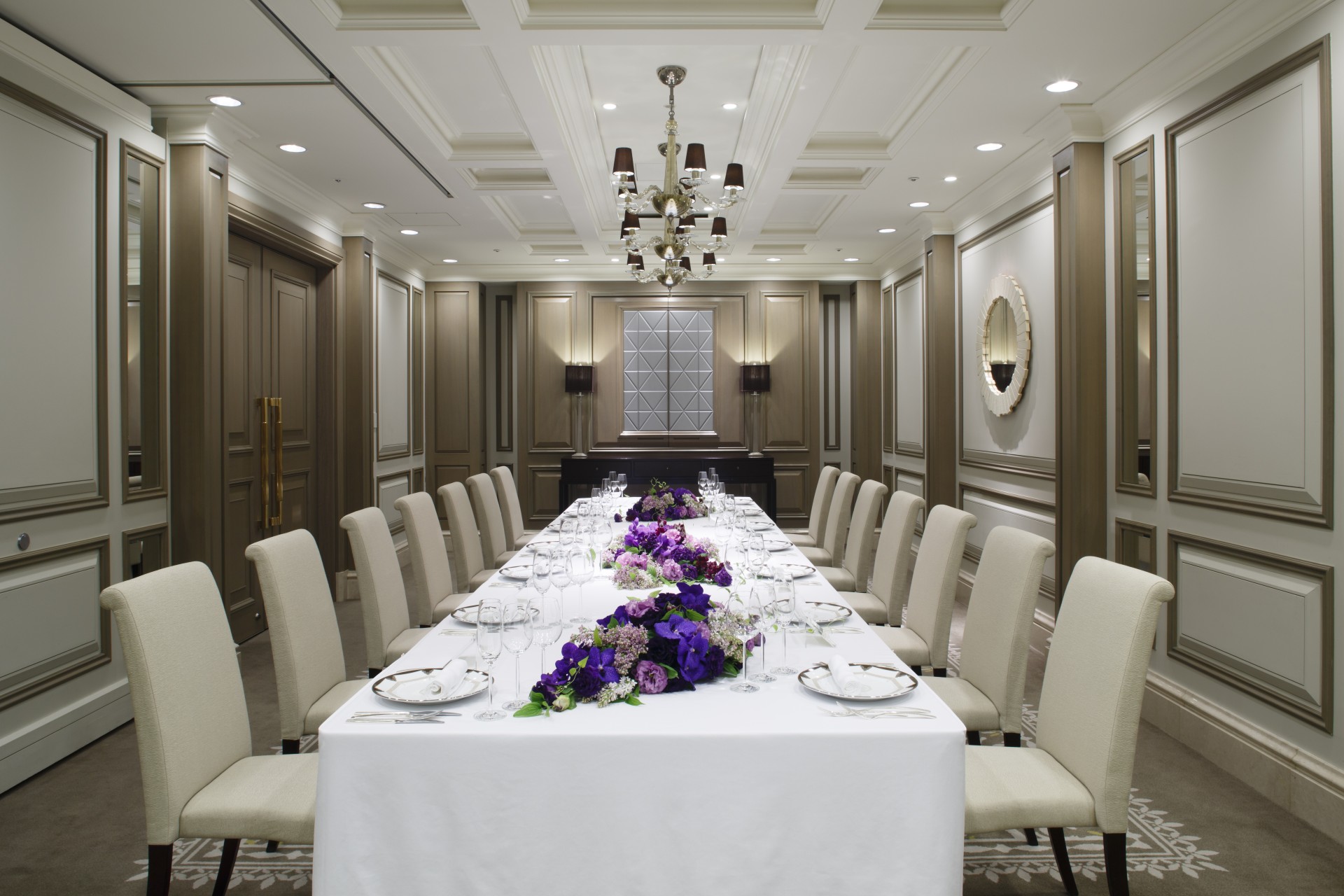 a long table with white tablecloths and purple flowers