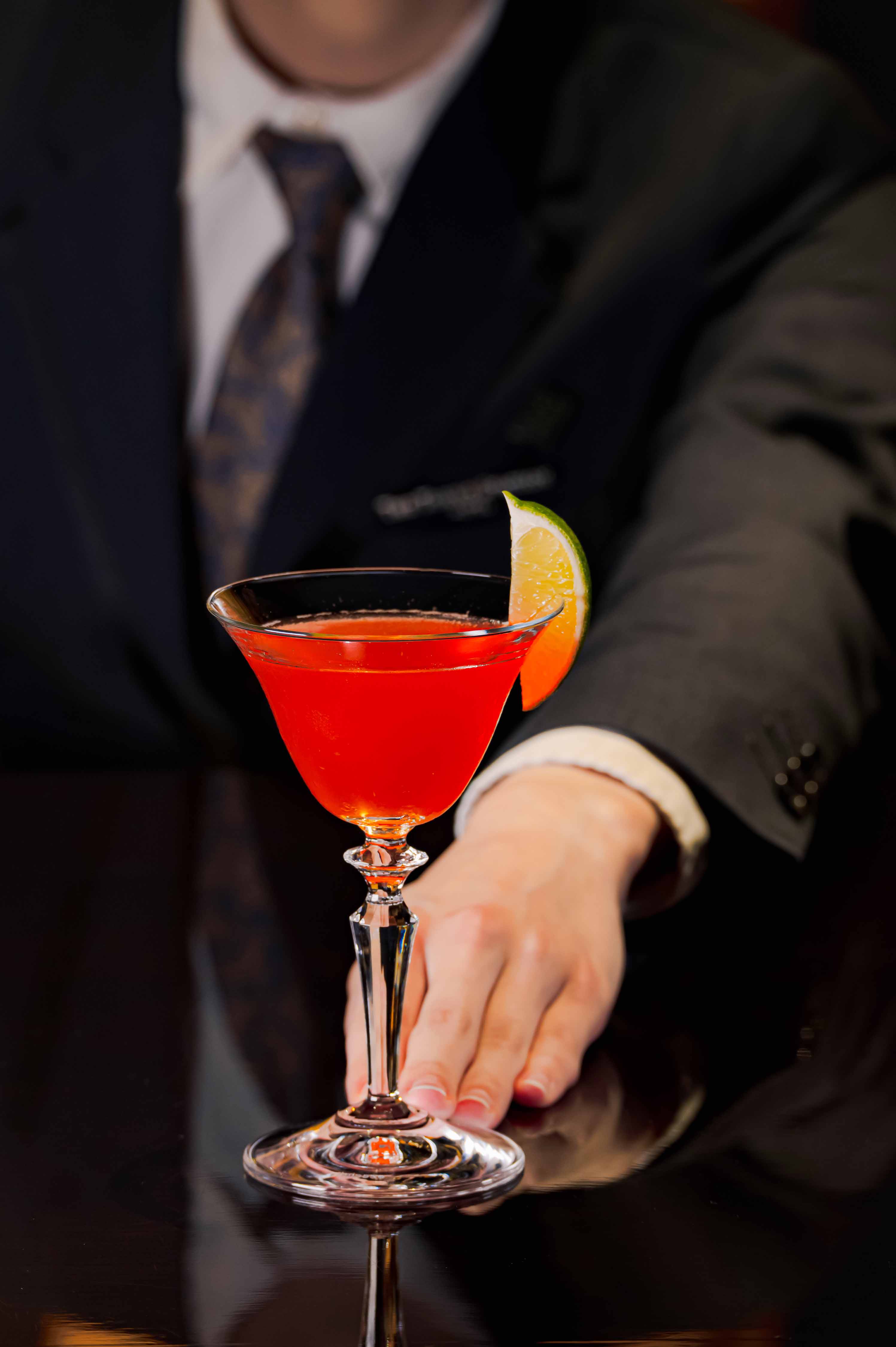 a hand holding a glass of red liquid