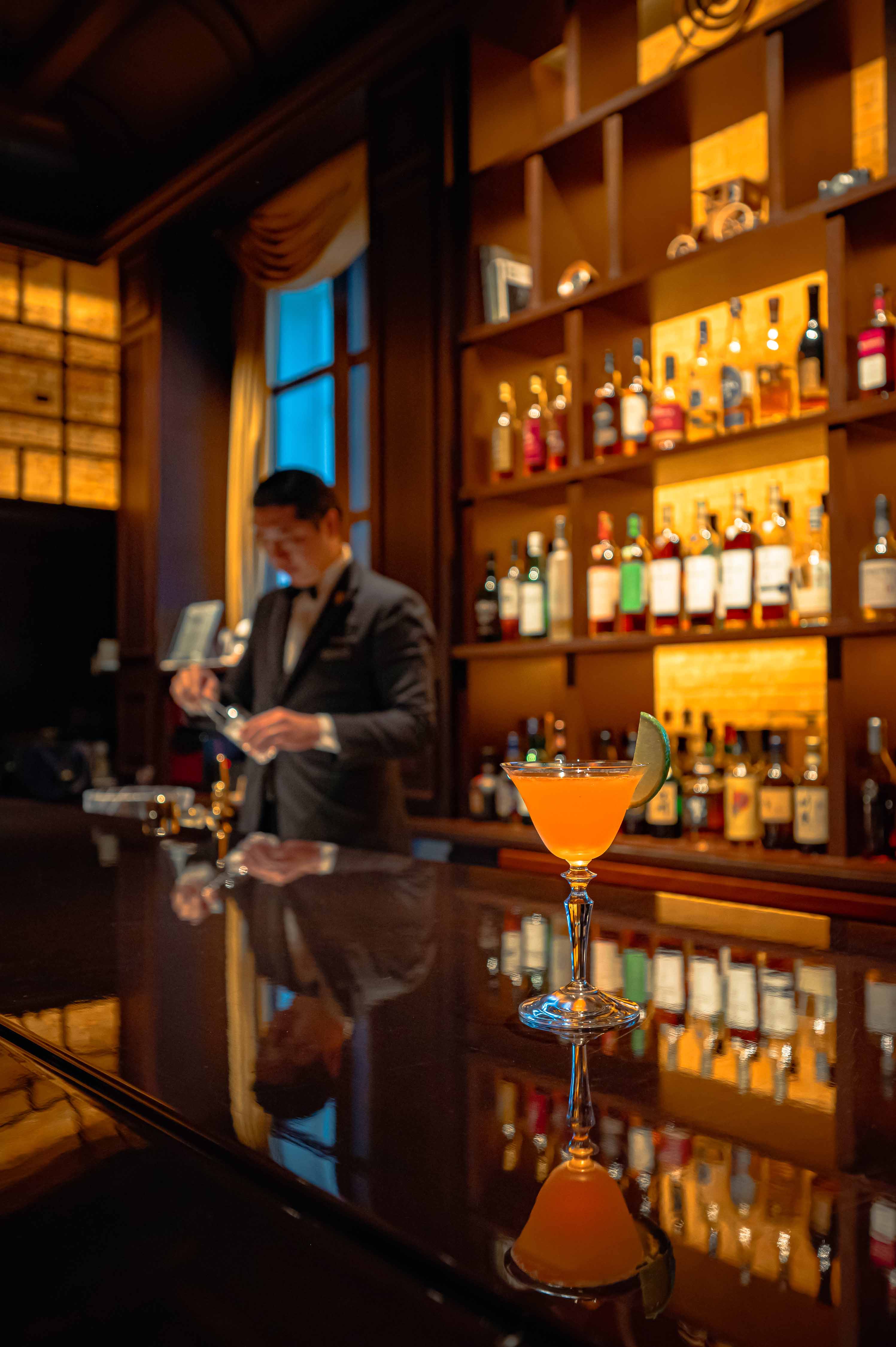 a glass of orange liquid on a bar counter