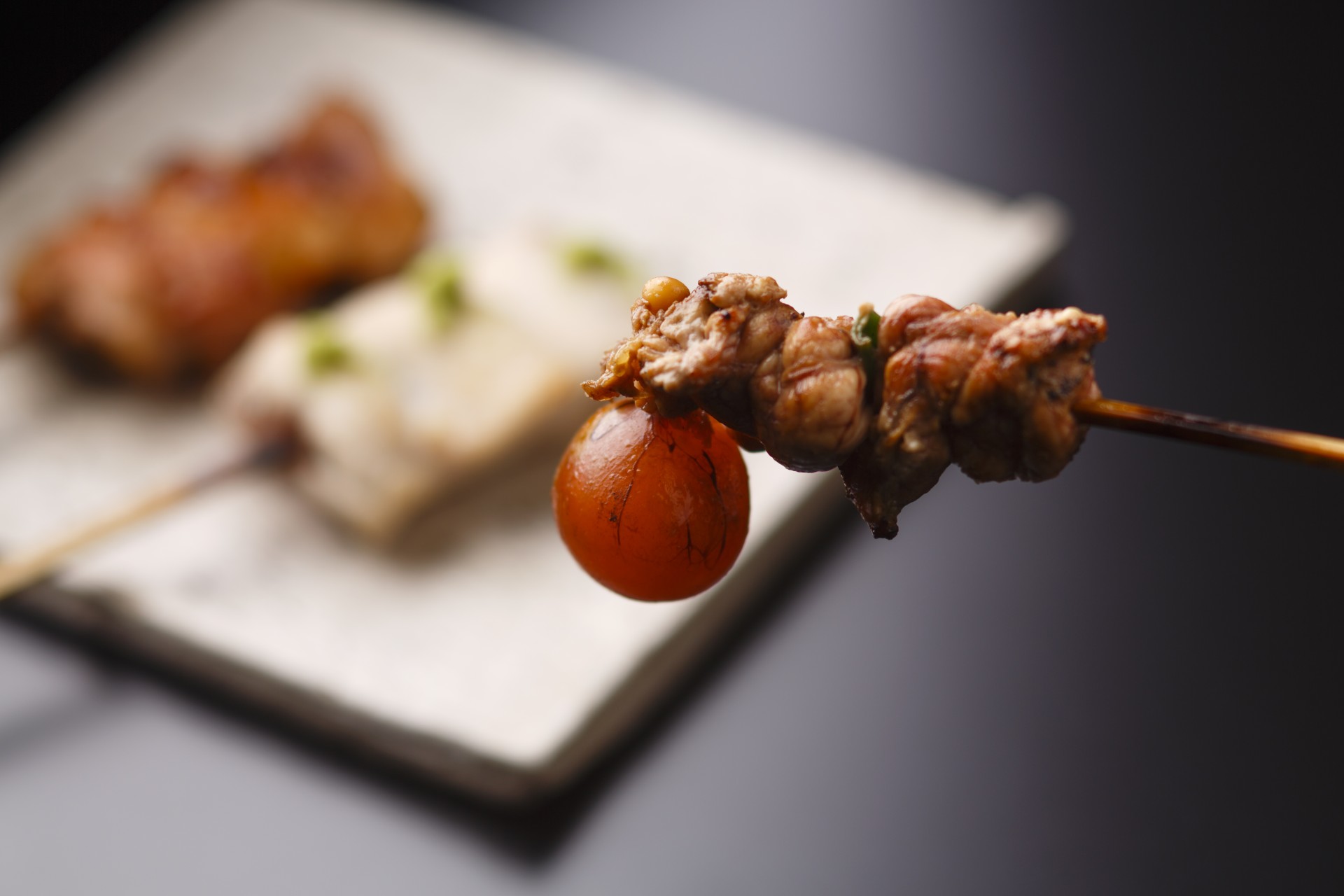 a skewer of meat and a tomato
