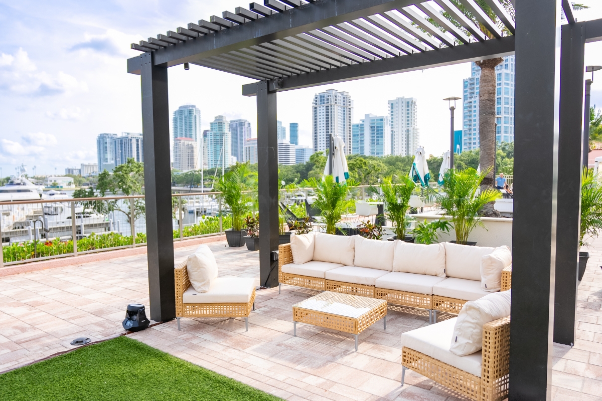 a patio with a pergola and a couch and chairs