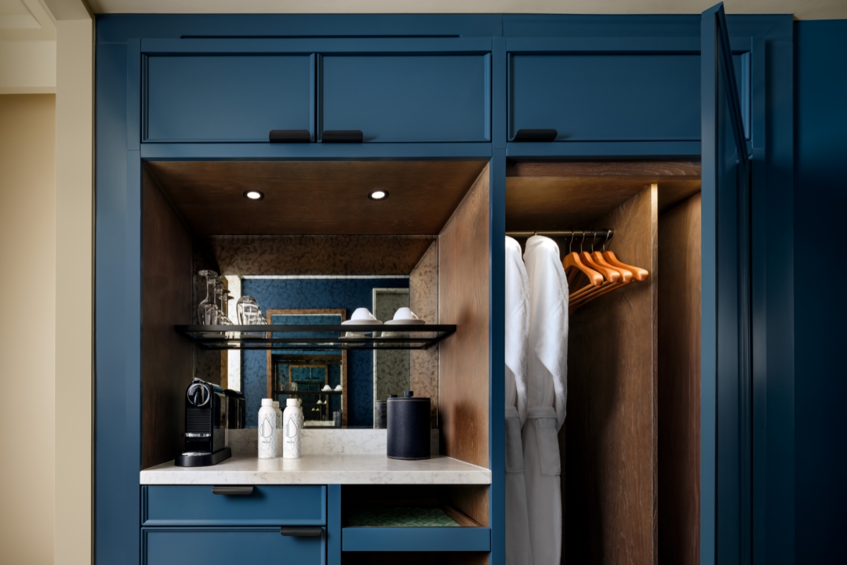 a bathroom with blue cabinets and white bathrobe
