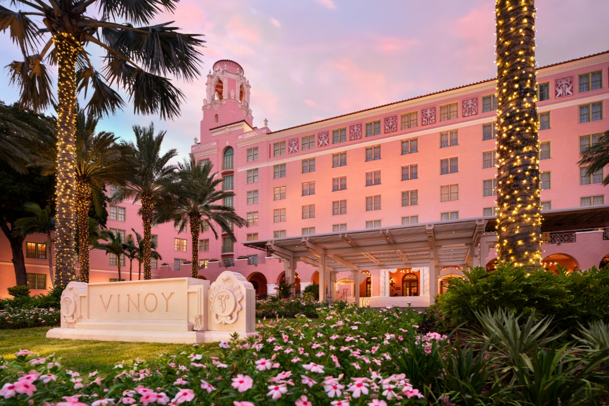a pink building with flowers and trees